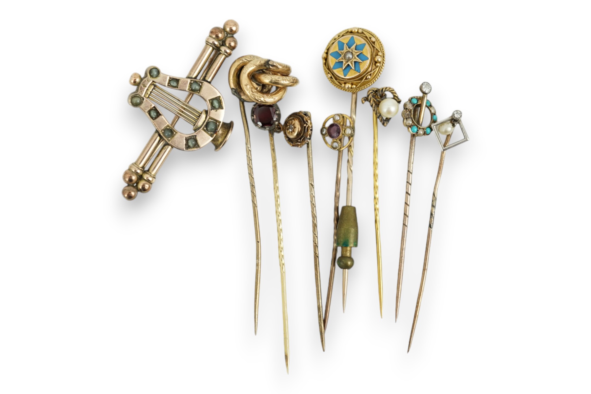 A Victorian yellow metal and cat's eye chrysoberyl set lyre bar brooch, 51mm and eight assorted gem set yellow metal stick pins including enamel and diamond set.